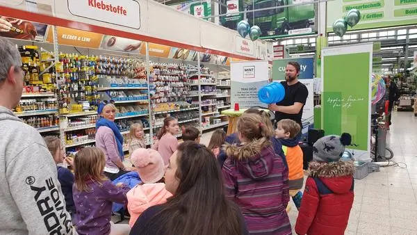 Wirbelringe-Experiment vor Kindern im Baumarkt